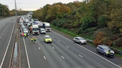 Carriageway of M25 closed as protesters climb gantires