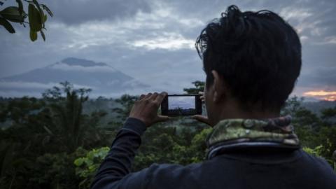 Man takes a photo of Mt Agung