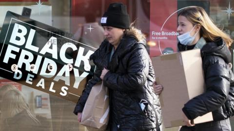 File photo of shoppers in Edinburgh walking past a Black Friday sign in a shop window
