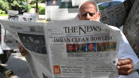 A man reads a morning newspaper in Islamabad on April 8, 2022