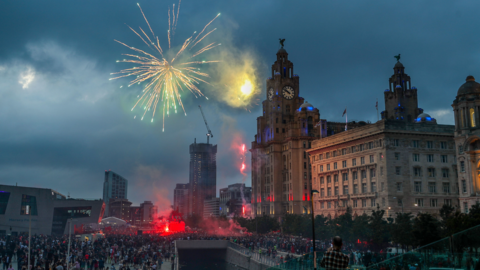 Firework lights up sky outside Liver Building