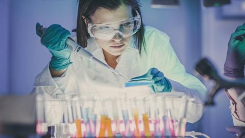 Woman scientist using pipette and test tubes