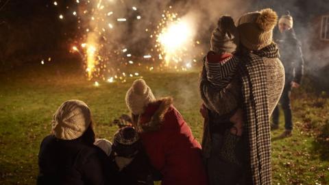 People lighting fireworks in their garden