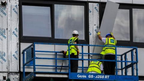 Cladding being removed from building