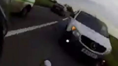 Moment before a motorbike collides with a van.