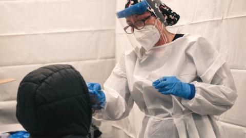 A medical worker administers a Covid-19 test at a new testing site inside the Times Square subway station on 27 December