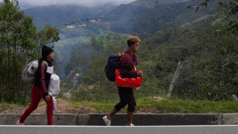 Ángel García and his partner Daniela Segueri walk along the road between Pamplona and Bucaramanga Colombia on October 1st. The couple from Valencia, Venezuela was heading to the city of Cali, and had been on the road already for seven days.