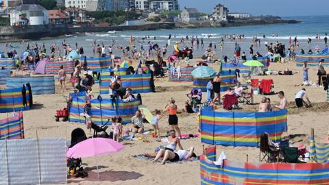 Crowds enjoy the hot weather at Portrush beach on Monday
