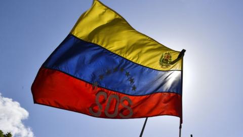 View of a Venezuelan national flag reading SOS during a rally in Caracas