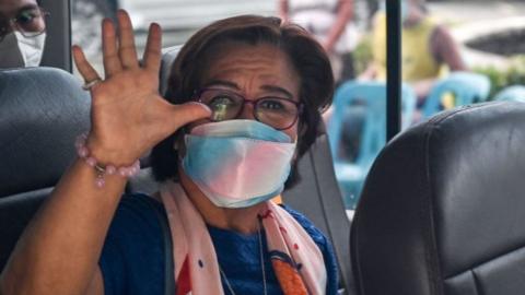 Leila de Lima, former Philippines senator, waves to news cameras after a court appearance in Manila.