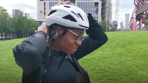 Woman putting on cycling helmet