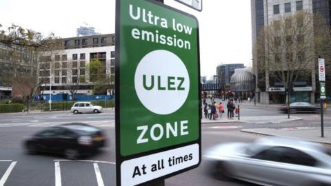 File photo of cars passing by a ULEZ sign in London.