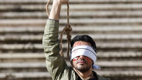 An Iranian-Portuguese man protests against the executions of two Iranian man in connection with the anti-government protests in Iran, in Lisbon, Portugal (16 December 2022)
