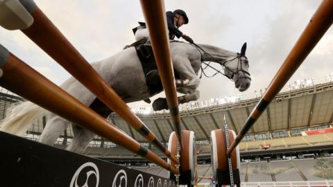 A horse jumps in modern pentathlon competition