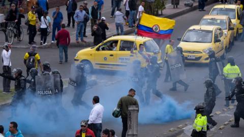 Police try to disperse taxi drivers amid protests against the private hire company Uber in Bogota, 23 October 2017