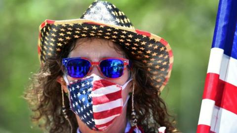 Woman wears mask in the colours of the US flag