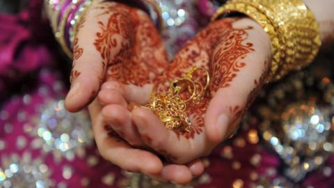 Bride holds wedding rings - Asian wedding, Bradford