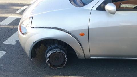 The car missing its front tyre