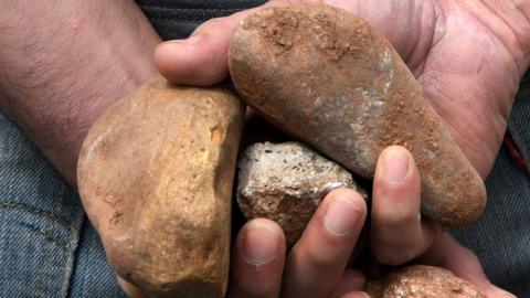 File image of person preparing to throw stones