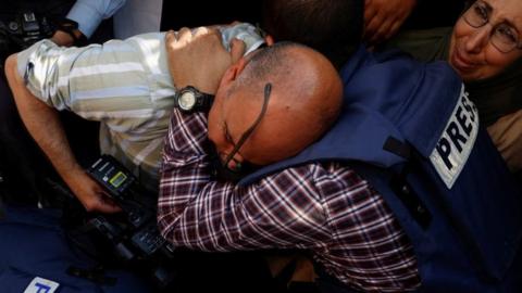 Journalists mourn next to the coffin of Al Jazeera correspondent Shireen Abu Aqla (11 May 2022)