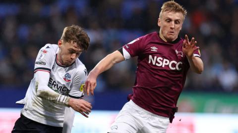 Conor Bradley of Bolton and Derby's Louie Sibley battle for possession