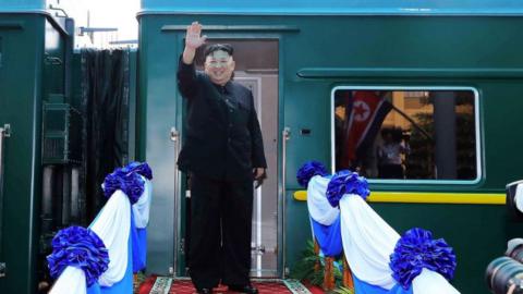 North Korea's leader Kim Jong Un waves before boarding his train