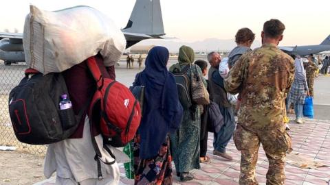 People walking towards planes waiting at Kabul airport