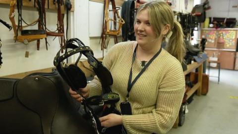 Bonnie Dale holds a saddle made at Capel Manor College