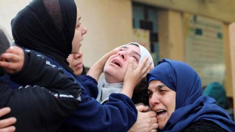 Three women in the aftermath of Isreali strike in Khan Younis, Gaza