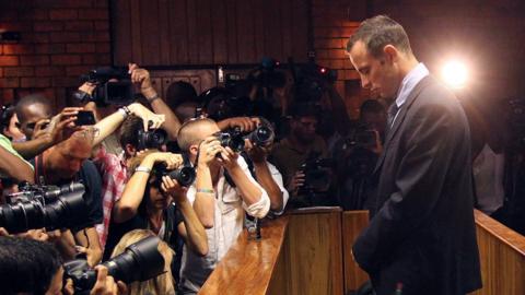 Photographers take pictures of Olympic athlete Oscar Pistorius as he appears at a bail hearing for the shooting death of his girlfriend Reeva Steenkamp, in Pretoria, South Africa, on Feb 22, 2013