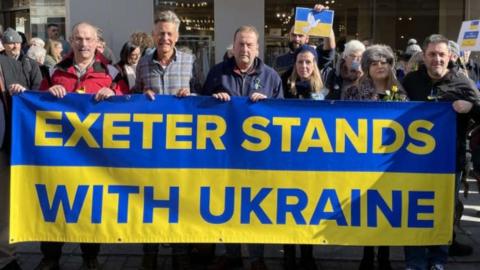 People holding up a banner at a vigil in Exeter in support of Ukraine