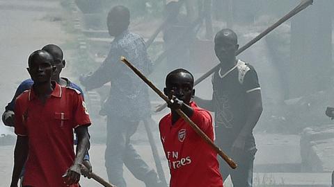 Members of the Imbonerakure, armed with sticks chase protestors opposed to the Burundian President's third term in the Kinama neighborhood of Bujumbura on May 25, 2015.