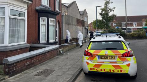 A police car parked outside the scene of the attack