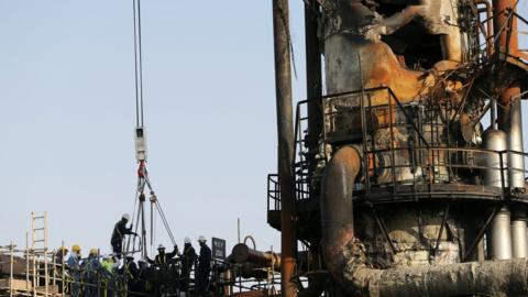 File photo showing workers inspecting damage at the Abqaiq oil facility in Saudi Arabia (20 September 2019)