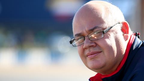 Rob Marshall poses on pit wall during Formula 1 winter testing