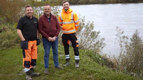 Peter Etchell, centre, with Quickline engineers Mike Anscombe (left) and Wesley Naulls at the location he fell into the River Trent