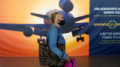 A woman arrives at Faro Airport on the first day that Britons are allowed to enter Portugal without needing to quarantine