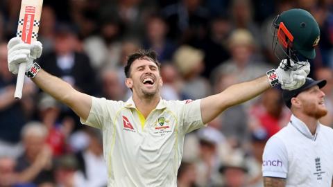 Mitchell Marsh raising his bat in celebration after hitting a century