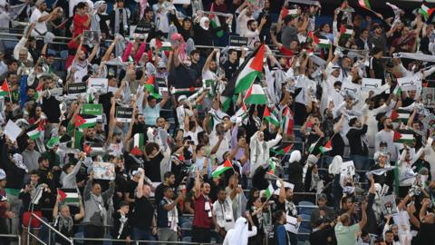 Fans wave Palestine flags at the World Cup qualifier against Australia