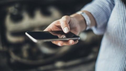 Woman holds mobile phone