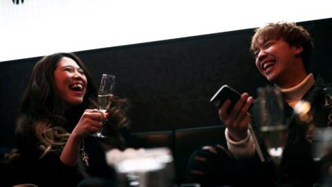 businesswoman Aki Nitta (L) drinks champagne