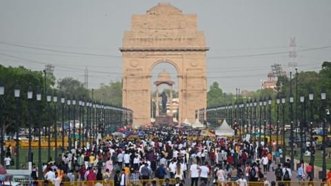 People crowd as they visit the India Gate in New Delhi on April 23, 2023