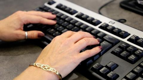 Woman typing on a keyboard