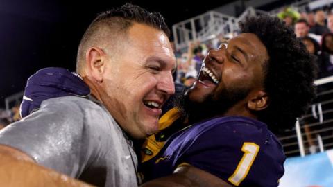 Desjuan Johnson celebrates with the Toledo Rockets' defensive coordinator Vince Kehres after beating the Liberty Flames in the Boca Raton Bowl game in 2022