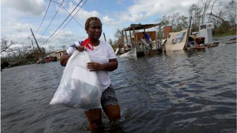 Louisiana resident wading through floodwaters