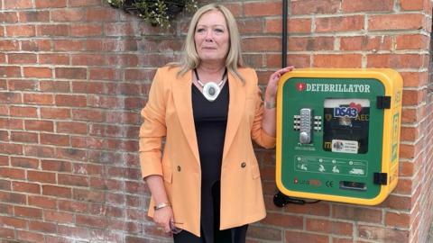 Pam Shurmer with an accessible defibrillator