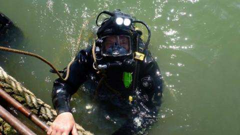 Diver Steve Ellis in the water with a diving suit on.