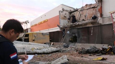 A policeman takes notes outside the premises of multinational company Prosegur after a robbery in Ciudad del Este, Alto Parana department, Paraguay (24 April 2017)