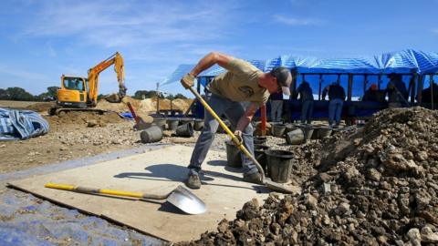 US military personnel dig for airman's remains.