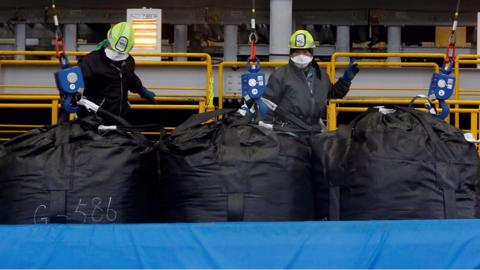 workers at a plant handling radioactive soil